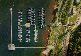 Vista aérea del puerto en Houseboat am Bärwalder See, con barcos atracados y vegetación junto al lago