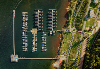 Luftfoto af Houseboat am Bärwalder See, der viser bådepladsen og de omkringliggende veje og grønne områder.