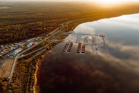 Vista aérea de casas flotantes y puerto deportivo en el lago Bärwalder See, Alemania, al atardecer.
