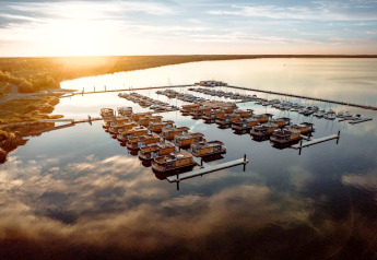 Sonnenuntergang am Houseboat am Bärwalder See mit mehreren Hausbooten und Yachten auf ruhigem Wasser.