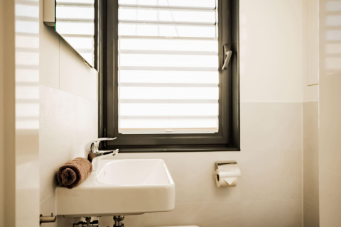 Modern bathroom on Houseboat am Bärwalder See with window, sink, toilet paper roll and a rolled towel.