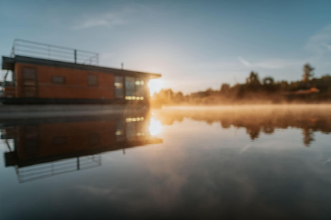 Alba riflessa sulla houseboat «am Bärwalder See» in Germania, sull’acqua calma del lago.