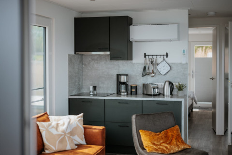 Moderne keuken en woonkamer op een woonboot bij Gräbendorfer See met apparaten en gezellig interieur.