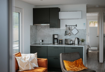 Cucina moderna e soggiorno su una casa galleggiante al Gräbendorfer See, con elettrodomestici e arredo accogliente.