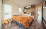 Moderne slaapkamer op een woonboot aan Gräbendorfer See met groot bed en uitzicht op het meer.