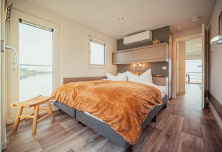 Camera moderna su una houseboat al Gräbendorfer See con letto matrimoniale e ampie finestre sul lago.