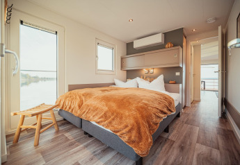 Camera moderna su una houseboat al Gräbendorfer See con letto matrimoniale e ampie finestre sul lago.