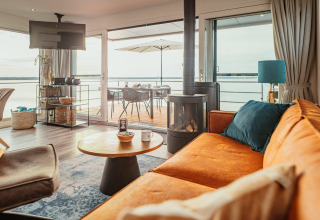 Heldere, moderne woonkamer op Houseboat am Gräbendorfer See met terras en uitzicht op het meer via glazen schuifdeuren.