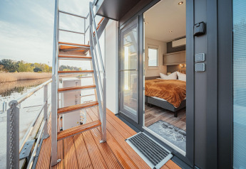 Udsigt fra terrassen på Houseboat am Gräbendorfer See med trappe og indgang til soveværelse.