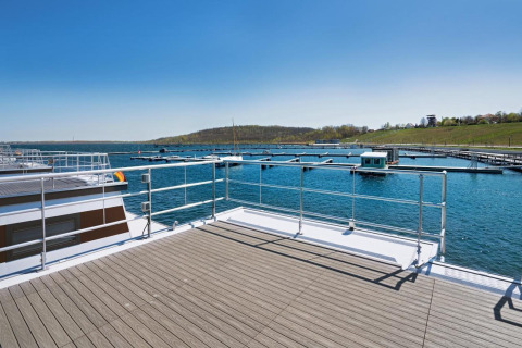 View from a houseboat with deck, marina, and lake under blue sky in Germany, Floating 33 - LP 16.