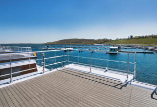 View from a houseboat with deck, marina, and lake under blue sky in Germany, Floating 33 - LP 16.