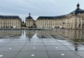 Uitzicht op Place de la Bourse in Bordeaux, Frankrijk, met een spiegelende waterpartij en klassieke gebouwen.