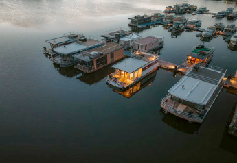 Luchtbeeld van woonboten bij Houseboat in Zehdenick, sommige sfeervol verlicht in de stille avond.