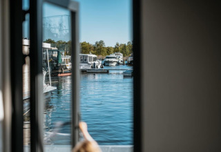 View from Houseboat in Zehdenick through an open door overlooking boats docked in the marina.