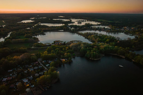 Aerial sunset photo of Houseboat in Zehdenick, Germany, nestled among rivers and lush green forests.