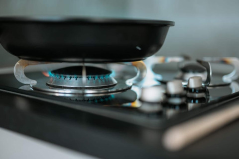 A black frying pan on a lit gas stove in the kitchen of the houseboat named 'Houseboat' in Zehdenick.