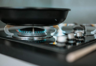 Una padella nera su un fornello a gas acceso nella cucina dell'houseboat 'Houseboat' a Zehdenick.