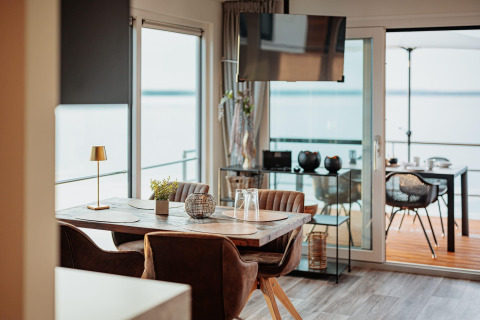 Modern dining area on a houseboat at Gräbendorfer See, with lake view and outdoor terrace visible.