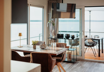 Moderne eetruimte op een woonboot aan Gräbendorfer See met zicht op het meer en buiten terras.