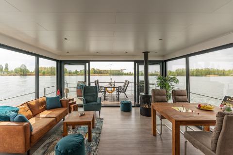 Spacious living room with panoramic windows on a houseboat in Zehdenick with water and deck views.