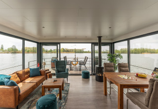 Soggiorno ampio con grandi finestre panoramiche su una houseboat a Zehdenick con vista acqua.