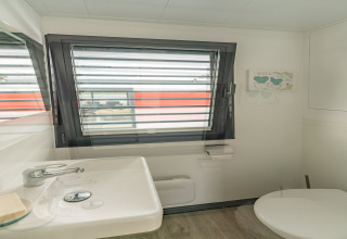 Baño con ventana y lavabo a bordo de la casa flotante 'in Zehdenick' en Alemania, moderno y luminoso.