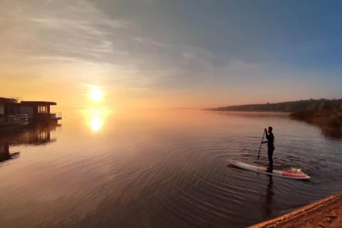 Zonsopgang boven de Gräbendorfer See met iemand op een paddleboard bij Houseboat am Gräbendorfer See.
