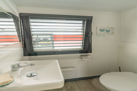 Bathroom on a houseboat in Zehdenick, Germany, with sink, toilet, window, and modern minimalist decor.
