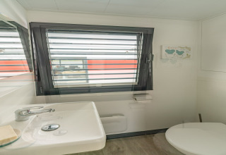 Baño en una casa flotante en Zehdenick, Alemania, con lavabo, inodoro, ventana y decoración moderna.