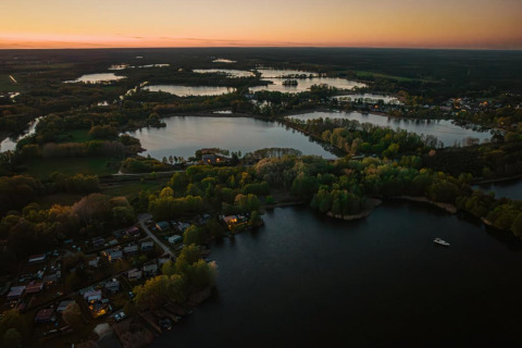 Vista aerea al tramonto della Houseboat «in Zehdenick» su un lago circondato da foreste in Germania.