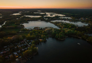 Aerial sunset view of Houseboat «in Zehdenick» on a scenic lake surrounded by forest in Germany.