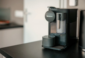 Nespresso-koffietoestel op zwart werkblad in de moderne keuken van een woonboot in Zehdenick, Duitsland.