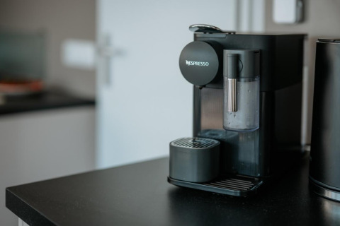 Nespresso coffee machine on a black counter in a modern kitchen of a houseboat in Zehdenick, Germany.