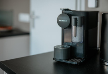 Machine à café Nespresso sur un comptoir noir dans la cuisine moderne d’une péniche à Zehdenick, Allemagne.