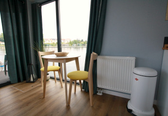 Kleine eethoek op Houseboat Friedrich met twee stoelen, tafel en prachtig uitzicht over het water.