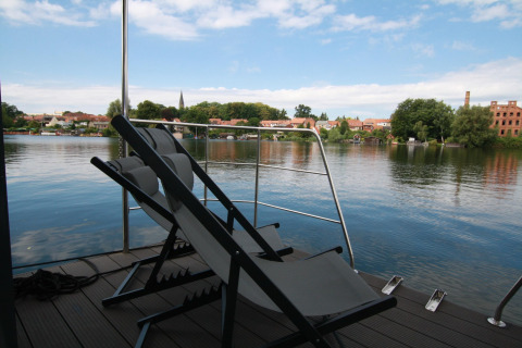 Due sdraio su una terrazza di houseboat con vista sul fiume e sulla città presso Houseboat Friedrich.