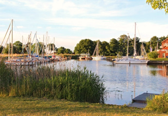 Uitzicht op de jachthaven vanaf houseboat 'Floating 44 Undine' in Duitsland, met zeilboten en groen.