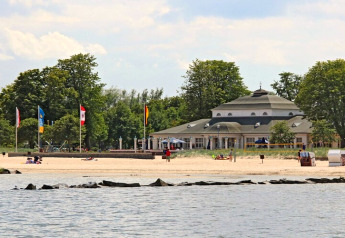 Blick vom Hausboot Floating 44 Undine in Deutschland, Strand, Meer und Gebäude im Hintergrund.