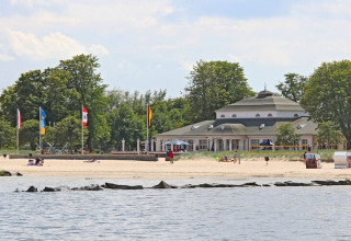 Vista dalla Houseboat Floating 44 Undine in Germania, spiaggia, mare ed edificio sullo sfondo.