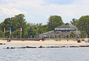 Udsigt fra Houseboat Floating 44 Undine i Tyskland, stranden, havet og bygning i baggrunden.