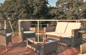 Buitenzitje op Houseboat «Xenia» in Duitsland met tuinmeubelen en zicht op omliggende bomen.