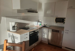 Cucina moderna su una houseboat con macchina da caffè, forno, lavello, microonde e lavastoviglie.