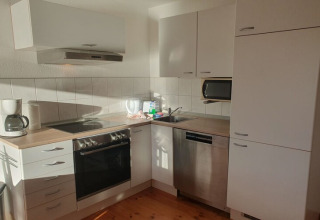 Bright, modern houseboat kitchen with stove, oven, dishwasher and coffee maker in natural sunlight.