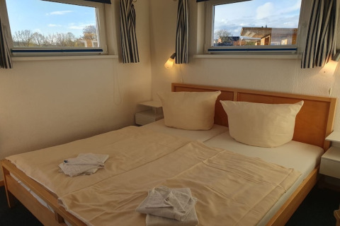 Accogliente camera da letto su una houseboat in Germania con letto matrimoniale e luce naturale.