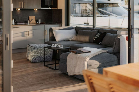 Moderne woonboot 475077 in Duitsland met gezellige woonkamer, keuken en ramen met uitzicht op een boot.