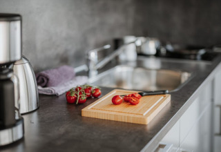 Moderne keuken met tomaten op een snijplank, een mes en een koffiezetapparaat op een woonboot in Duitsland.