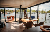 Modernes Wohnzimmer auf einem Hausboot in Peenemünde mit Blick auf den Hafen und einer Terrasse.
