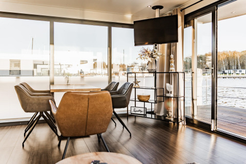 Foto degli interni della houseboat 'in Peenemünde' in Germania, con zona pranzo moderna e ampie finestre.