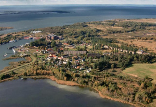 Vue aérienne de Peenemünde au bord de la mer, avec une maison flottante et des espaces verts.