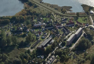 Vue aérienne de Peenemünde avec la ville, l'eau et des péniches dans un paysage verdoyant paisible.